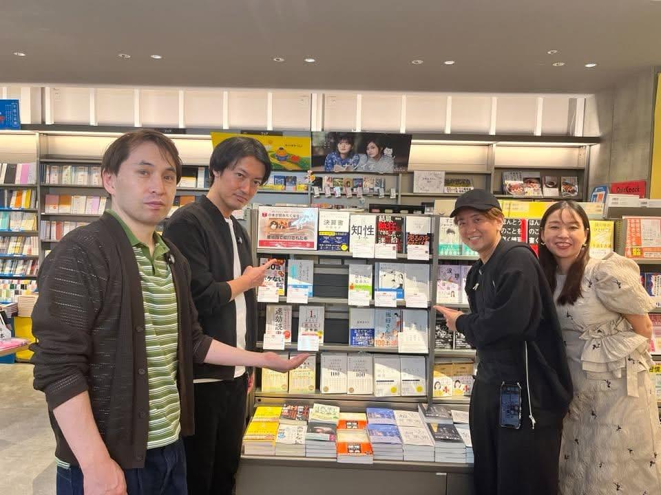 「本ラジ」コーナーの棚の前に立つ、矢島和郎、小寺裕樹、大隅元、あつみゆりか