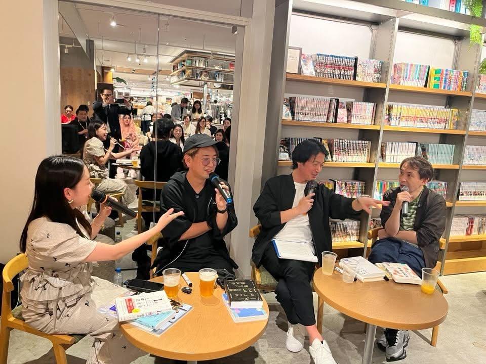 ビールを手に向かい合って座り、トークをするあつみゆりかと3人の編集長。奥に客席が見える