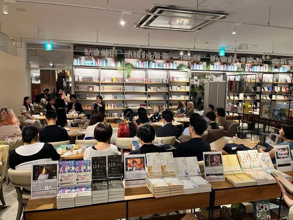 客席の手前の机に並べられた、この夜の紹介本。奥で登壇者が話している